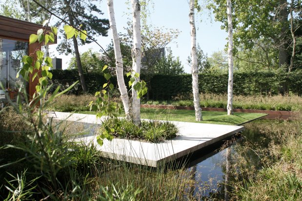 Floatng concreet terras | strong cortensteel edge | in contrast with wild green tones | Garden architecture by Andrew van Egmond